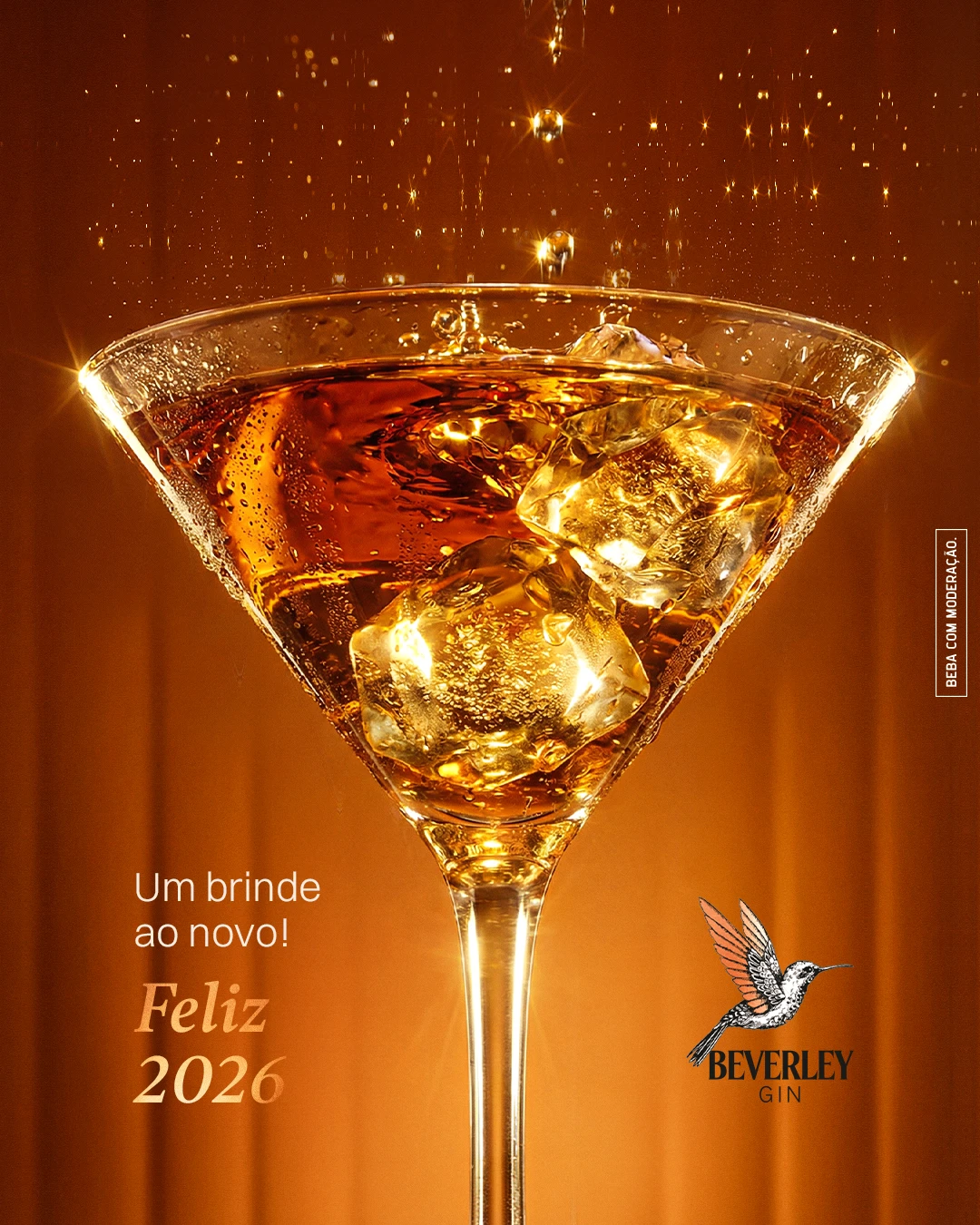 Post "Um brinde ao novo! Feliz 2026": taça de drink âmbar com gelo sob gotas douradas, com o logo Beverley Gin